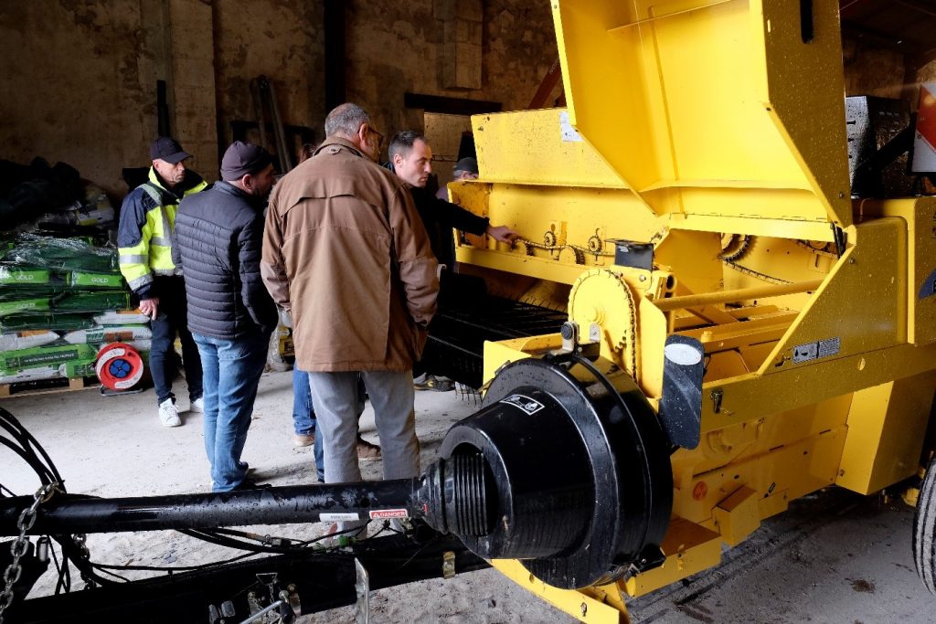 Les jardiniers devant la botteleuse : une sacrée machine !